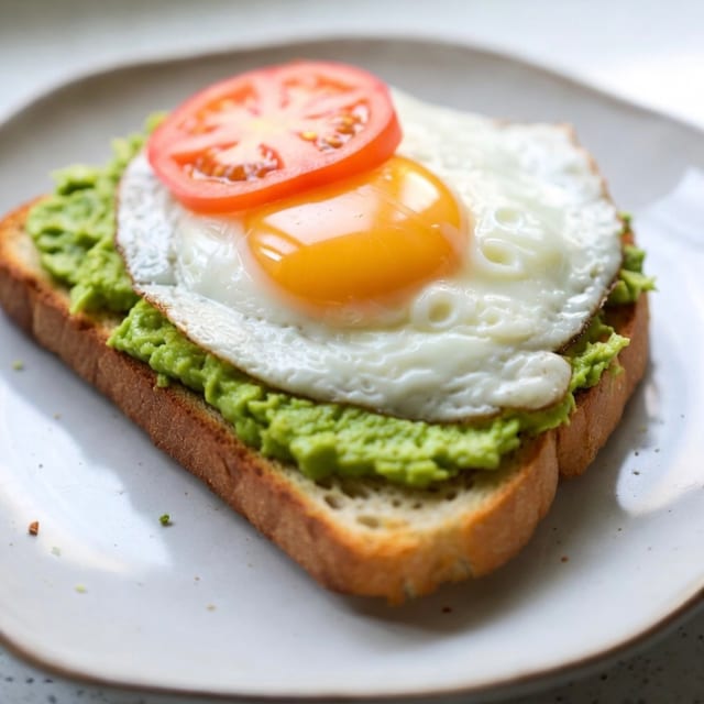Avocado Toast, fried egg & grilled tomato.