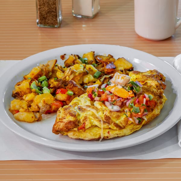 A Breakfast Club and Grill omelet with pico de gallo and a side of home fries.