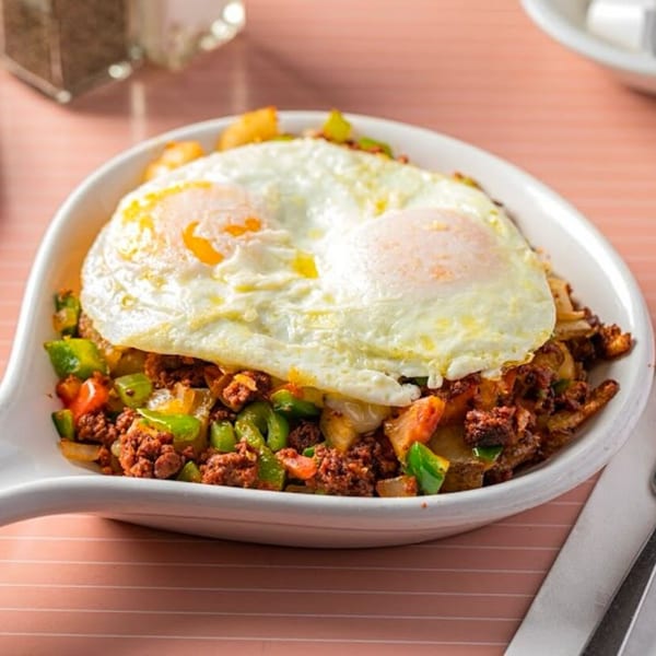 A Breakfast Club and Grill chorizo hash with bell peppers, onions, and two fried eggs.
